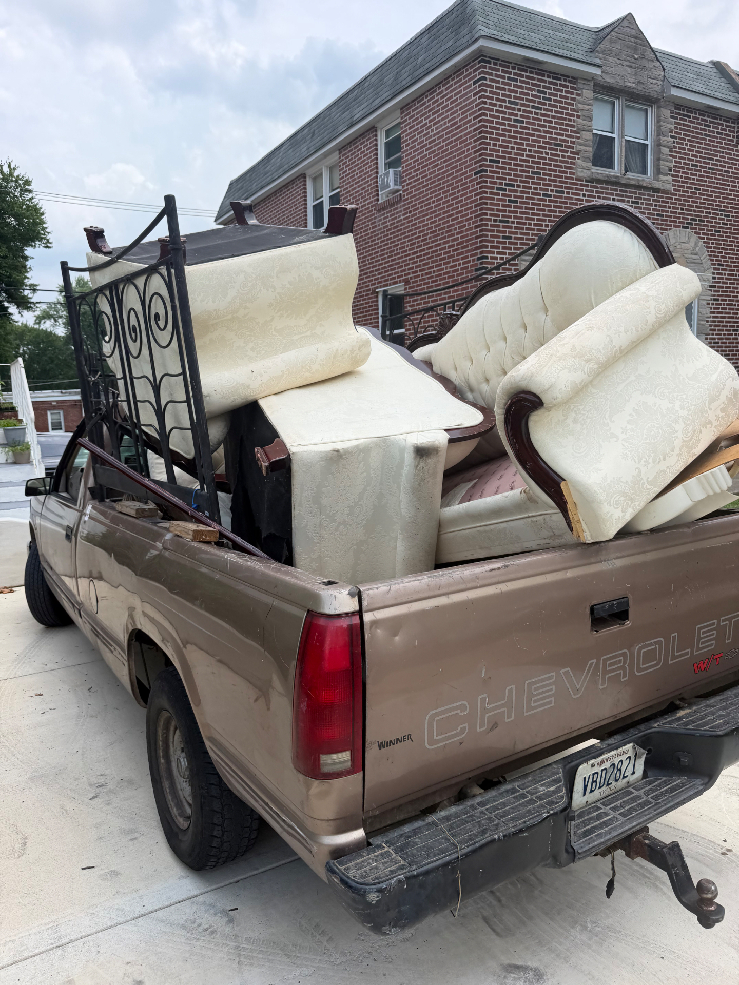 B.L.O.O.M. Entity pickup truck fully loaded with couches, headboard and metal railings hauled from the driveway