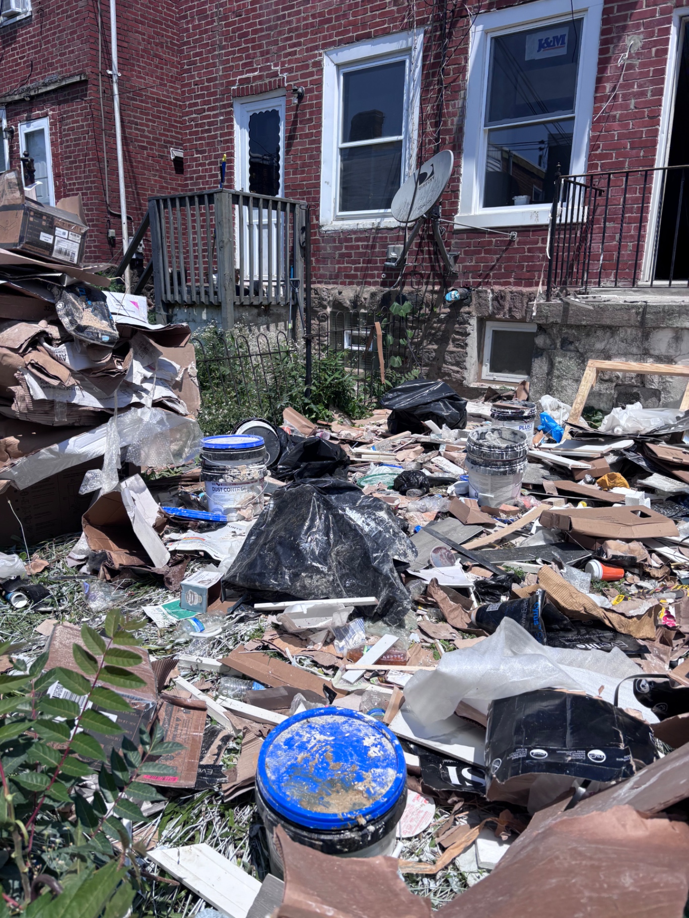 Debris-filled Philadelphia rowhome yard before B.L.O.O.M. Entity crew arrived